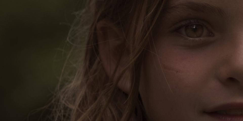 Half a face in warm light.
One eye steady, alert.
Wind moves through loose strands of hair.
The frame holds only what is necessary.
The rest remains outside, unseen.