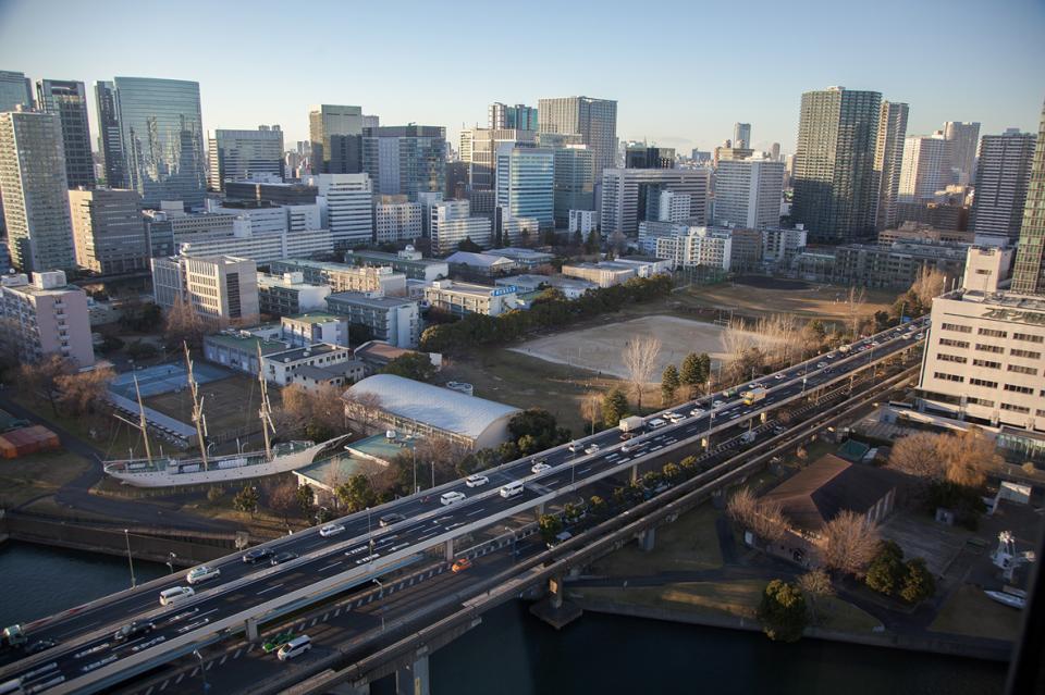 Morning light over steel and glass.
Highways carry the current of cars.
And there — a ship on land.
Out of place.